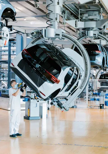 Operario inspeccionando vehículo Volkswagen en cadena montaje