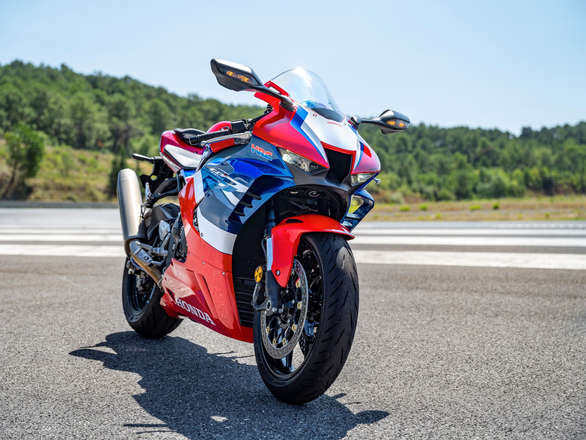 Vista trasera-lateral Honda CBR1000RR-R Fireblade en circuito, exponiendo su diseño deportivo y aerodinámico.