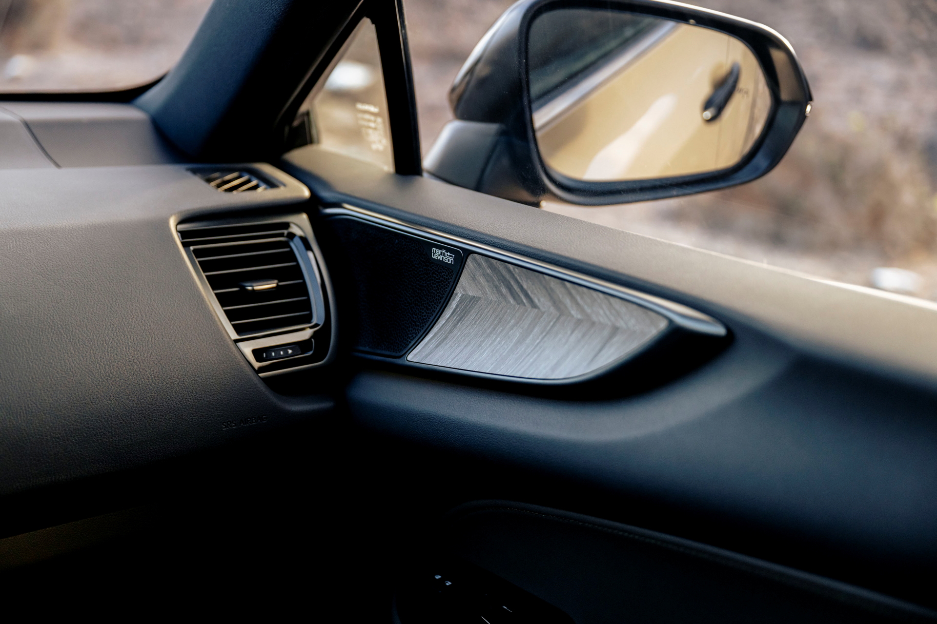 Vista del espejo lateral y acabados interiores del Lexus NX.