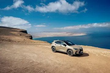 Lexus NX 350h Overtrail junto al mar, muestra su línea lateral y capacidades todoterreno.