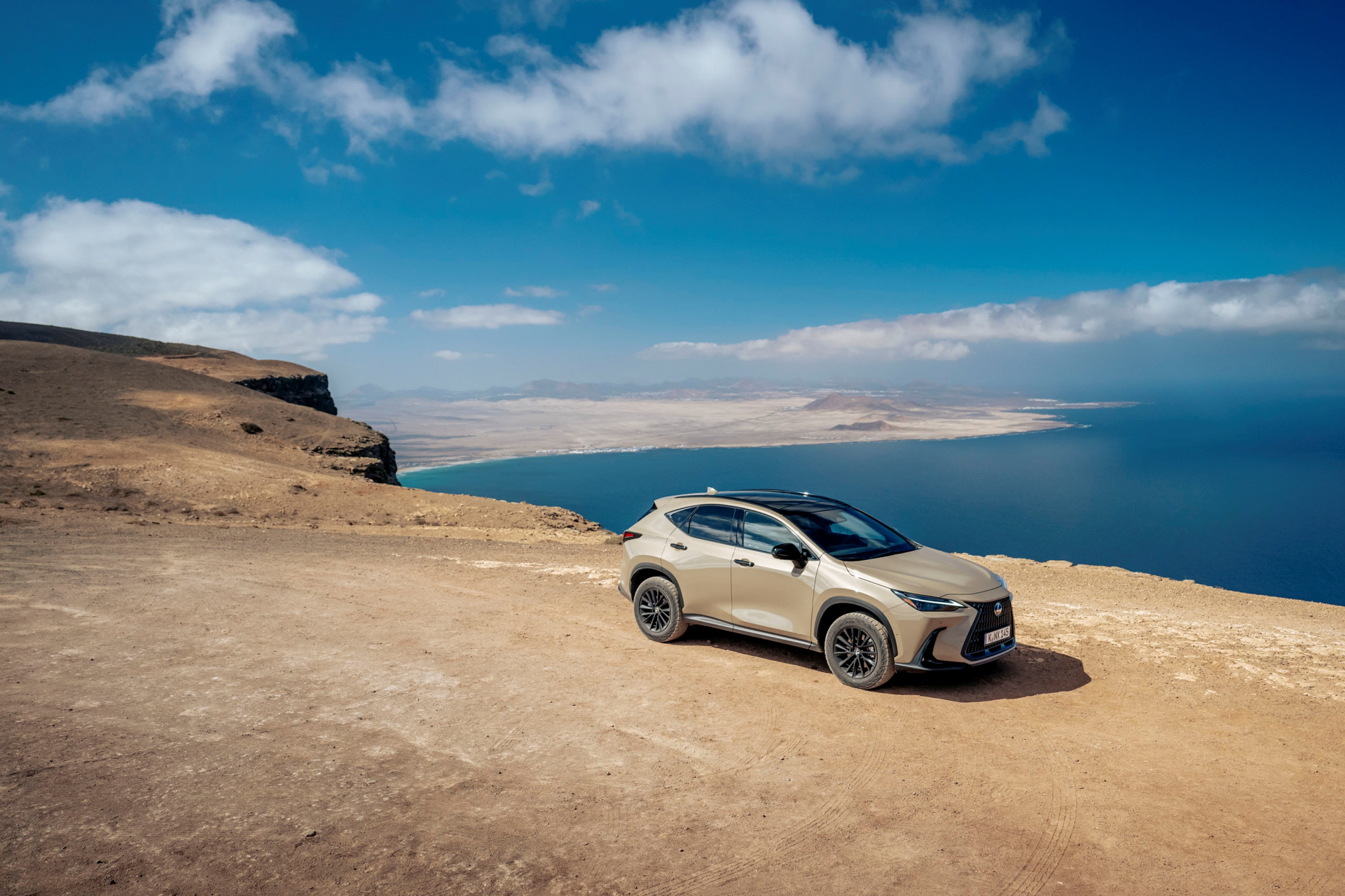 Lexus NX 350h Overtrail junto al mar, muestra su línea lateral y capacidades todoterreno.