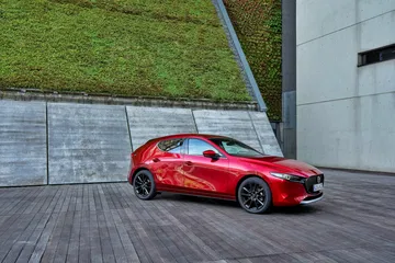Vista lateral del Mazda 3 2025 en color rojo destacando su dise&ntilde;o aerodin&aacute;mico