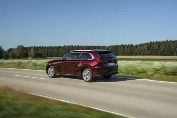 Vista dinámica del Mazda CX-80 en carretera, destacando su línea lateral.
