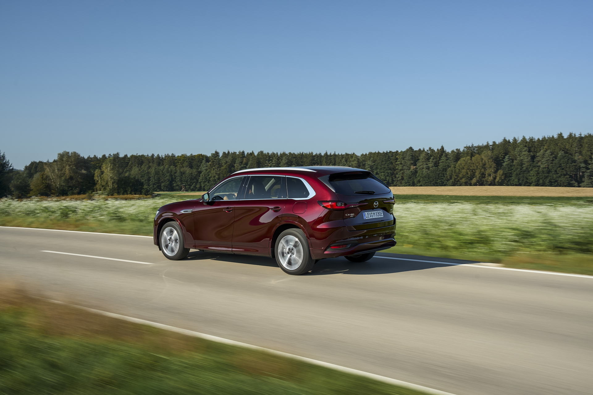 Vista dinámica del Mazda CX-80 en carretera, destacando su línea lateral.