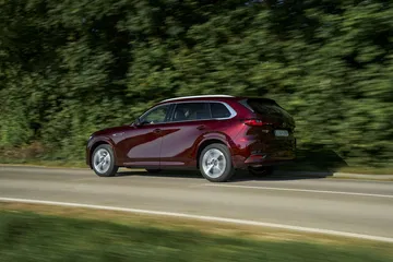 El Mazda CX-80 2025 capturado en movimiento, reflejando su estilizada silueta.