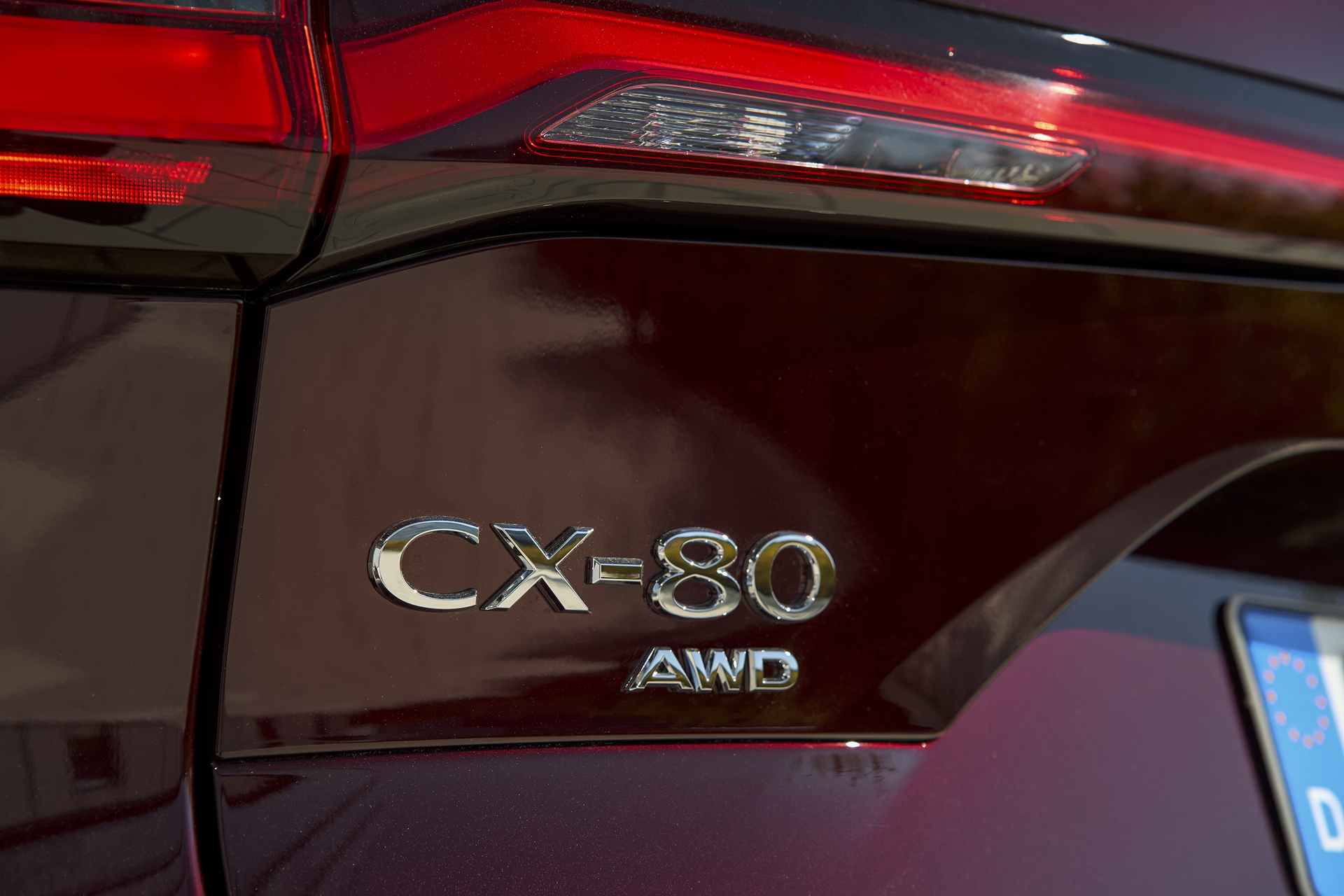 Vista cercana del emblema CX-80 en la carrocería de un Mazda.