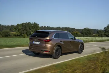 El Mazda CX-80 demuestra elegancia y robustez con su diseño trasero y perfil lateral.