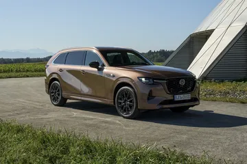 Vista lateral del Mazda CX-80, resaltando su perfil atlético y diseño moderno.