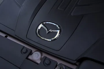 Detalle del logo Mazda en el volante, calidad y elegancia.