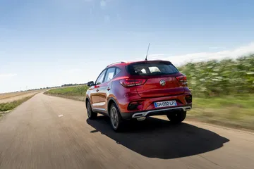 Vista dinámica del MG ZS en pleno desplazamiento, destacando su línea lateral y diseño moderno.
