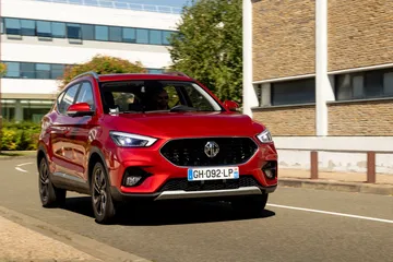 Vista dinámica del MG ZS, mostrando su diseño frontal y lateral en entorno urbano.