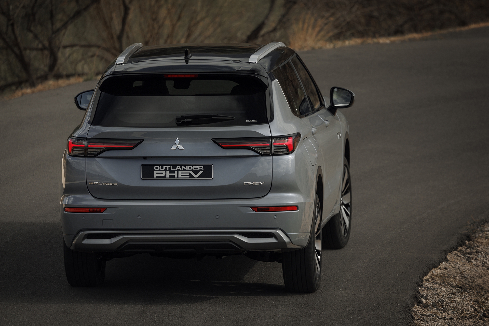 Vista dinámica del Mitsubishi Outlander PHEV mostrando su diseño robusto y aerodinámico.
