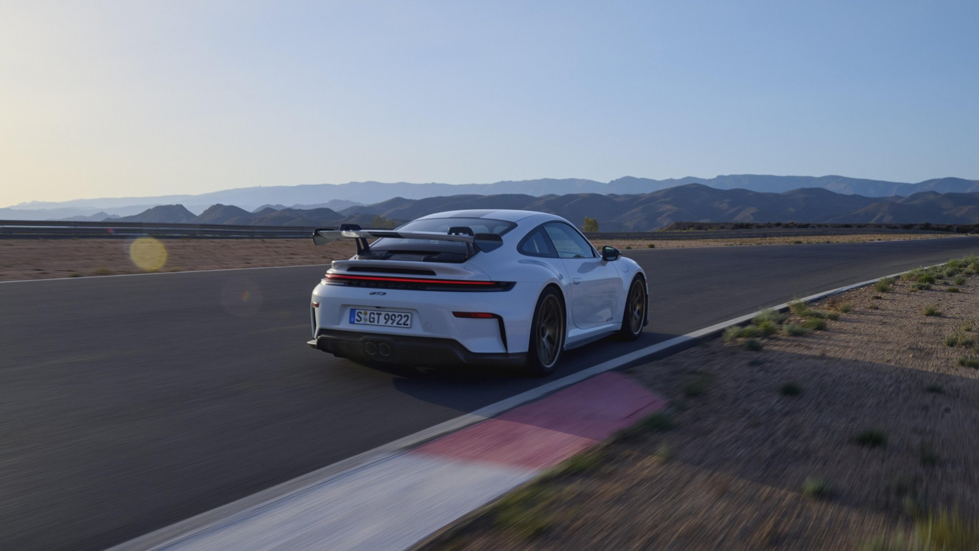 Vista dinámica del Porsche 911 GT3 992 en circuito, demostrando su elegancia y poderío.