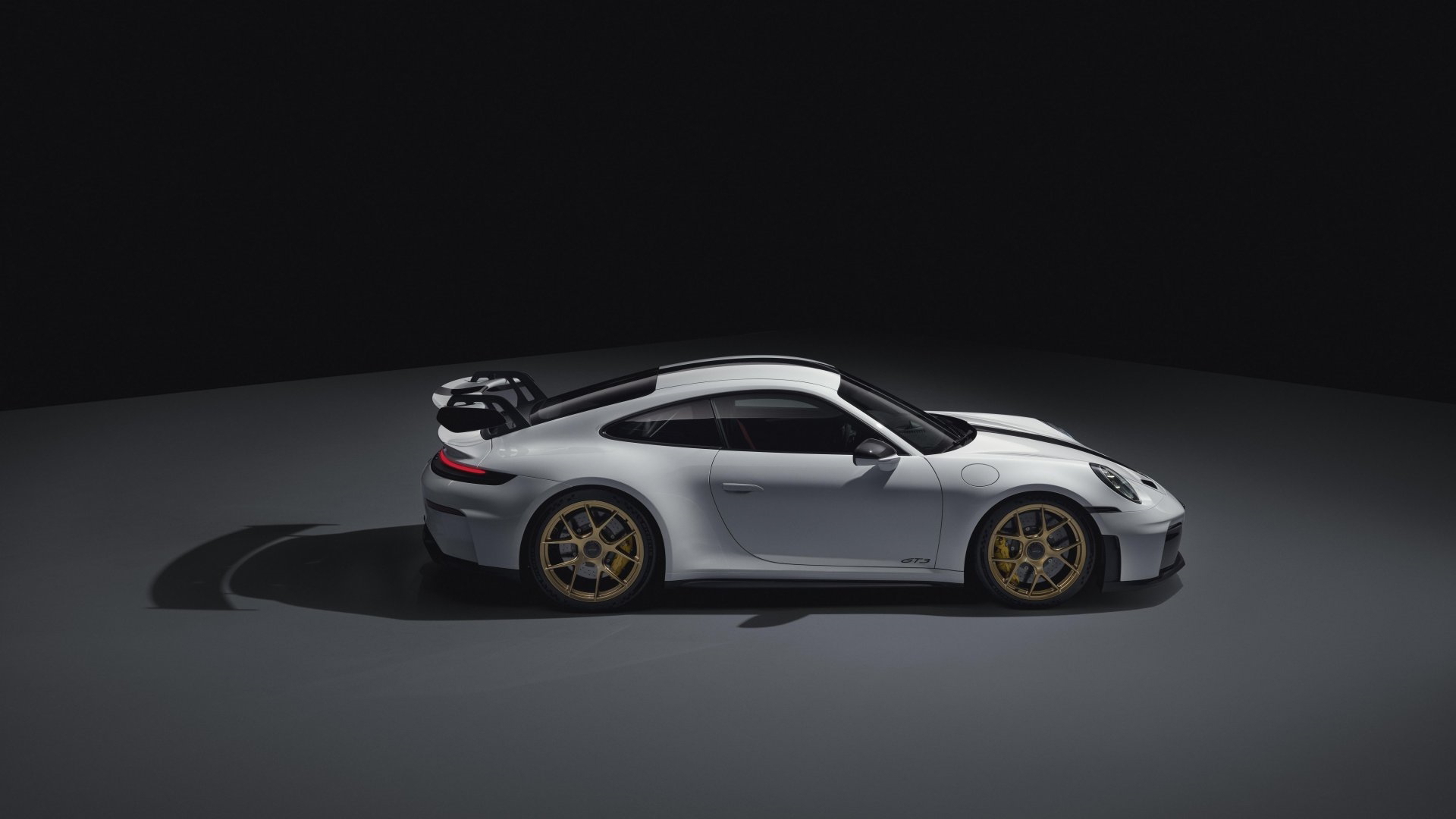Vista lateral Porsche 911 GT3 992 destacando sus líneas aerodinámicas y deportivas.