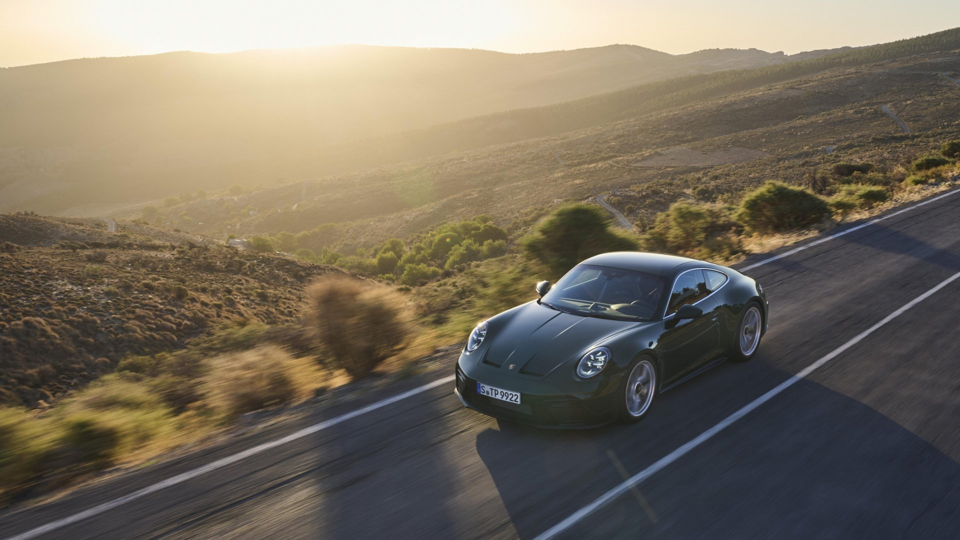 Porsche 911 GT3 capturado en dinámica carretera, luz natural realza líneas.