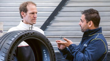 Ingenieros evaluando neumático de Porsche, detalle de calidad.