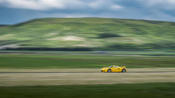 Porsche Carrera GT amarillo capturado en pleno dinamismo lateral.