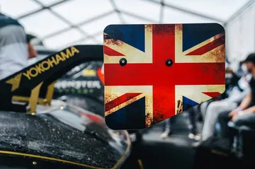 Vista trasera lateral del Radford en Goodwood, alardea de su herencia británica con la bandera.