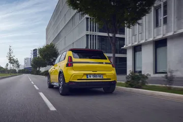 Vista trasera lateral del Renault 5 en movimiento, destacando su diseño retro-moderno.