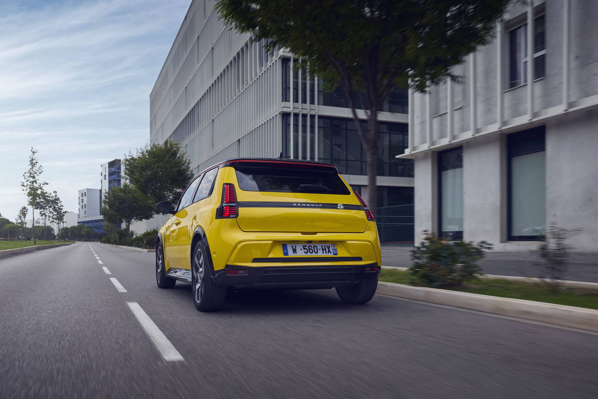 Vista trasera lateral del Renault 5 en movimiento, destacando su diseño retro-moderno.