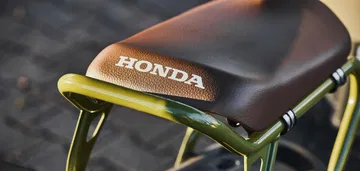 Asiento mostrando el emblema de Honda con estructura de soporte visible.