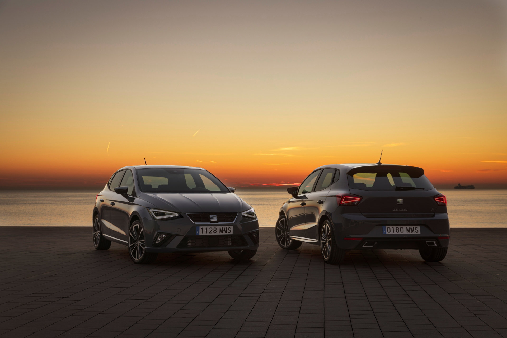 Dos SEAT Ibiza perfilados frente a la puesta de sol, evocando estilo y tradición.