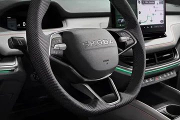 Vista detallada del volante con inserciones de diseño ergonómico.