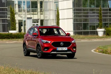 Vista del MG ZS en movimiento, destacando su frontal dinámico y líneas laterales.