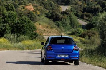 Vista en dinámica del Suzuki Swift 2024, destacando su diseño trasero y lateral.