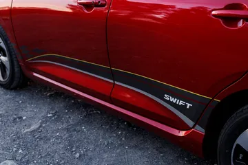 Vista lateral del Suzuki Swift 2024, destacando su diseño compacto y líneas modernas. Vista lateral del Suzuki Swift 2024, destacando su diseño compacto y líneas modernas.
