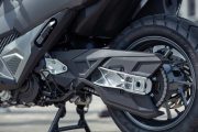 Vista cercana de la mecánica de una motocicleta, enfocando en los detalles de la suspensión y el sistema de frenos.