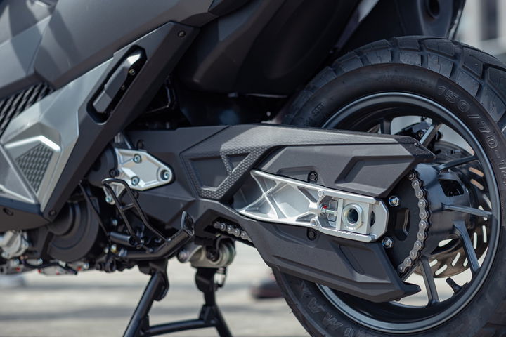 Vista cercana de la mecánica de una motocicleta, enfocando en los detalles de la suspensión y el sistema de frenos.