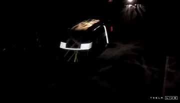 Vista nocturna frontal del Tesla Cybercab, escasa iluminación