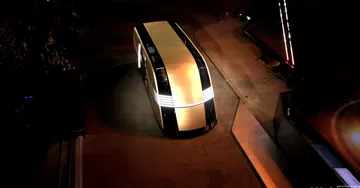 Tesla CyberCab lateral en ambiente oscuro, iluminación destacada.