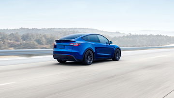 Vista dinámica del Tesla Model Y mostrando su línea trasera y lateral en movimiento.