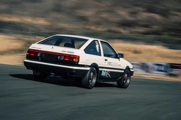 Toyota AE86 en acción, mostrando su perfil dinámico y trasero icónico.