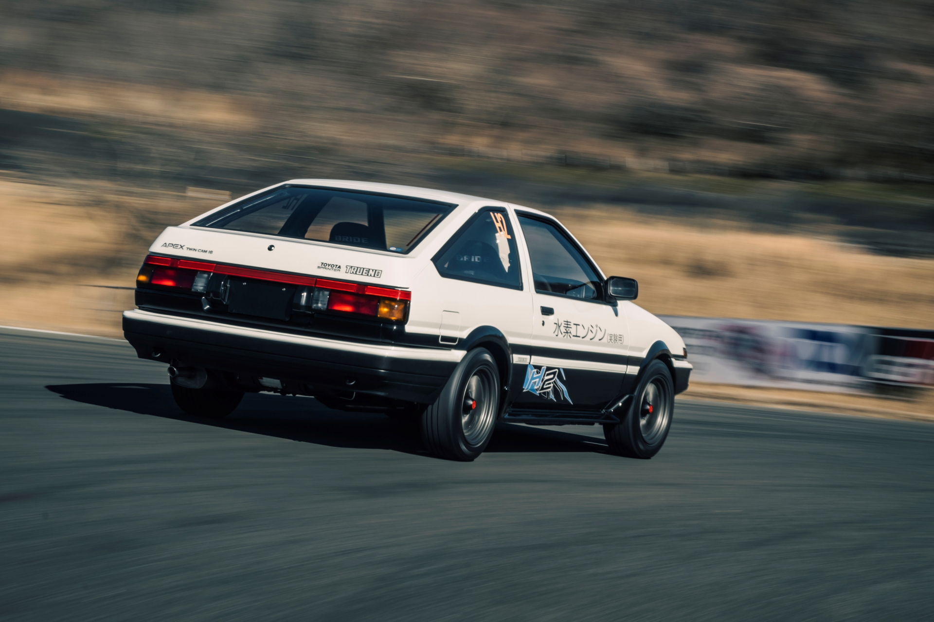 Toyota AE86 en acción, mostrando su perfil dinámico y trasero icónico.