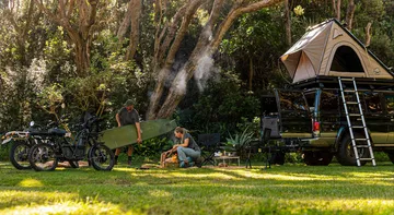 Vista lateral de la e-bike UBCO 2x2 aparcada en entorno natural