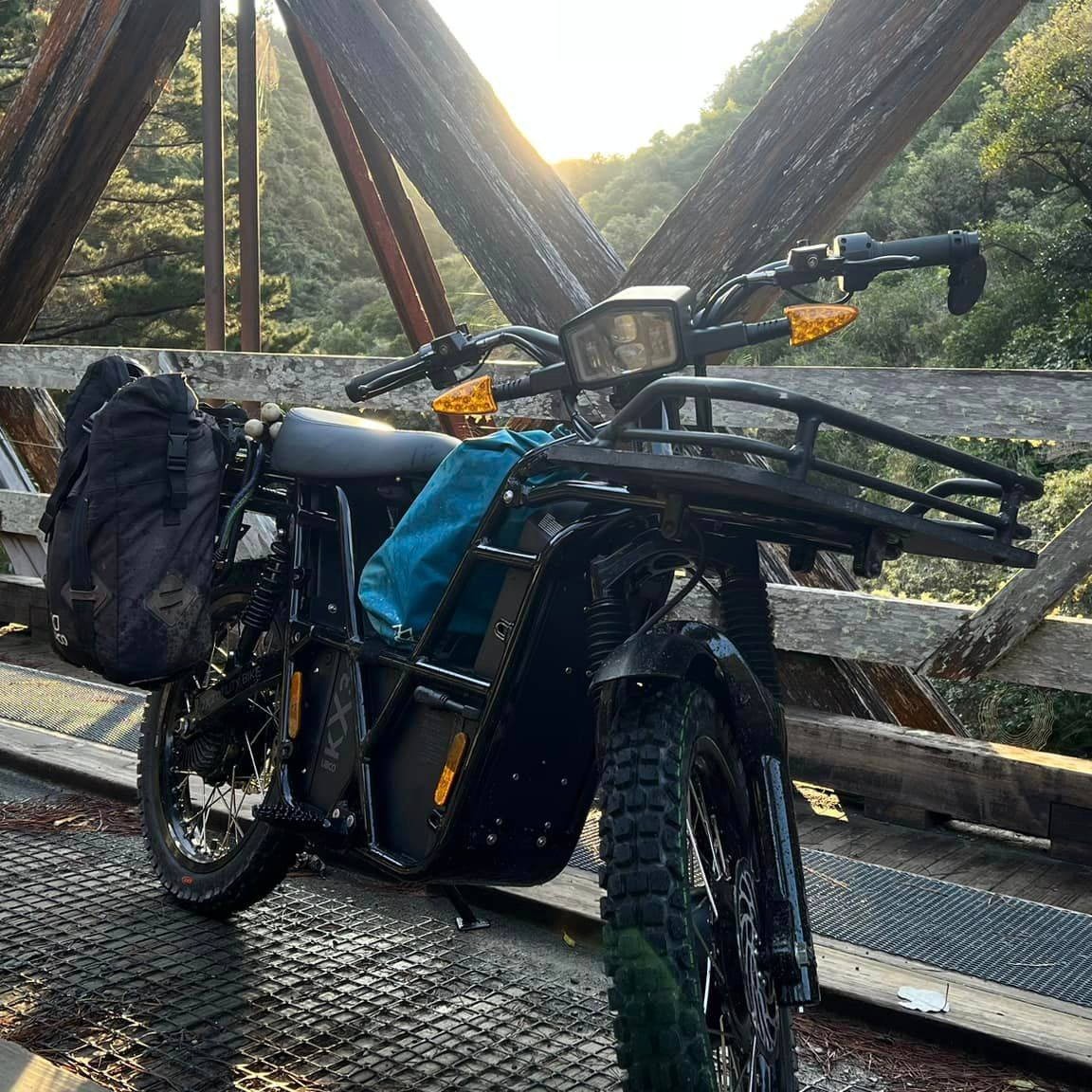 Vista lateral de la UBCO 2x2, una motocicleta eléctrica con diseño robusto para terrenos difíciles.