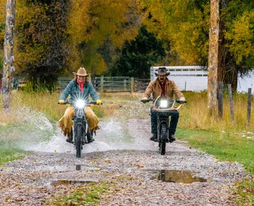 Dos e-bikes UBCO 2x2 superando terrenos acuáticos con solvencia.