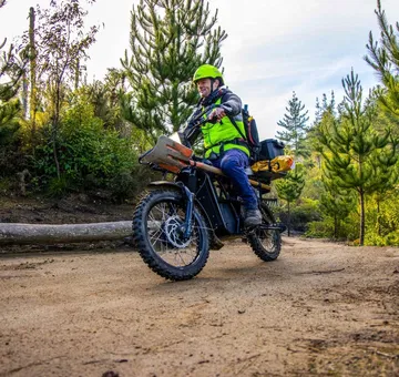 Innovadora ebike UBCO 2x2 en pleno dinamismo por terreno off-road.
