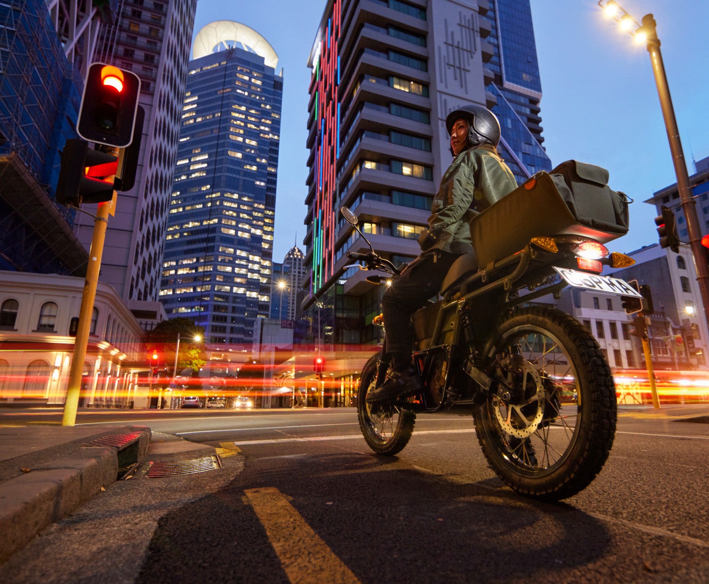 Moto eléctrica UBCO 2x2 capturada de perfil en un entorno urbano nocturno.