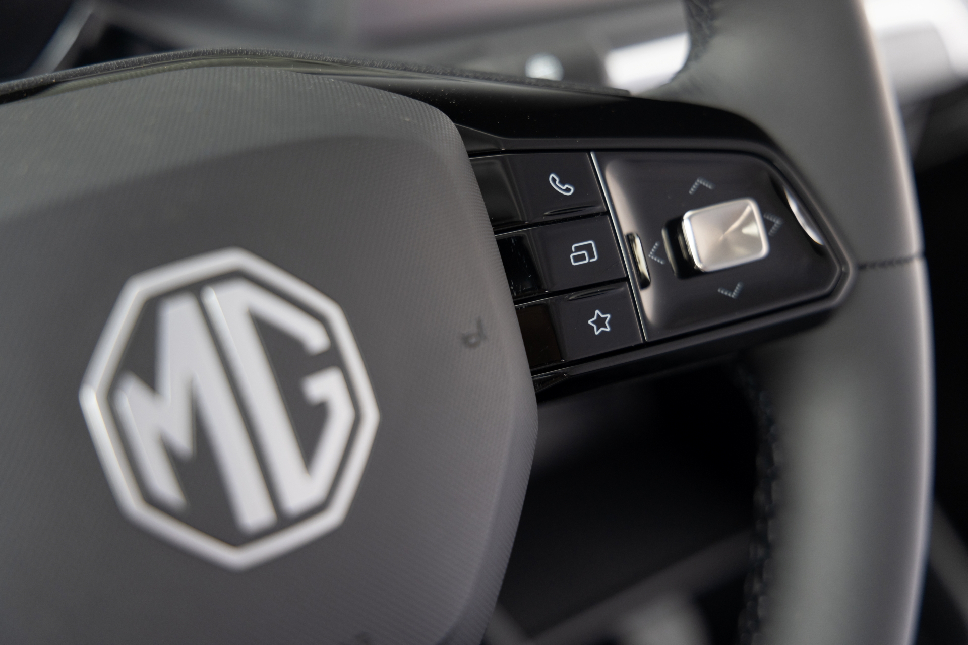 Volante con controles multimedia y emblema MG en relieve.
