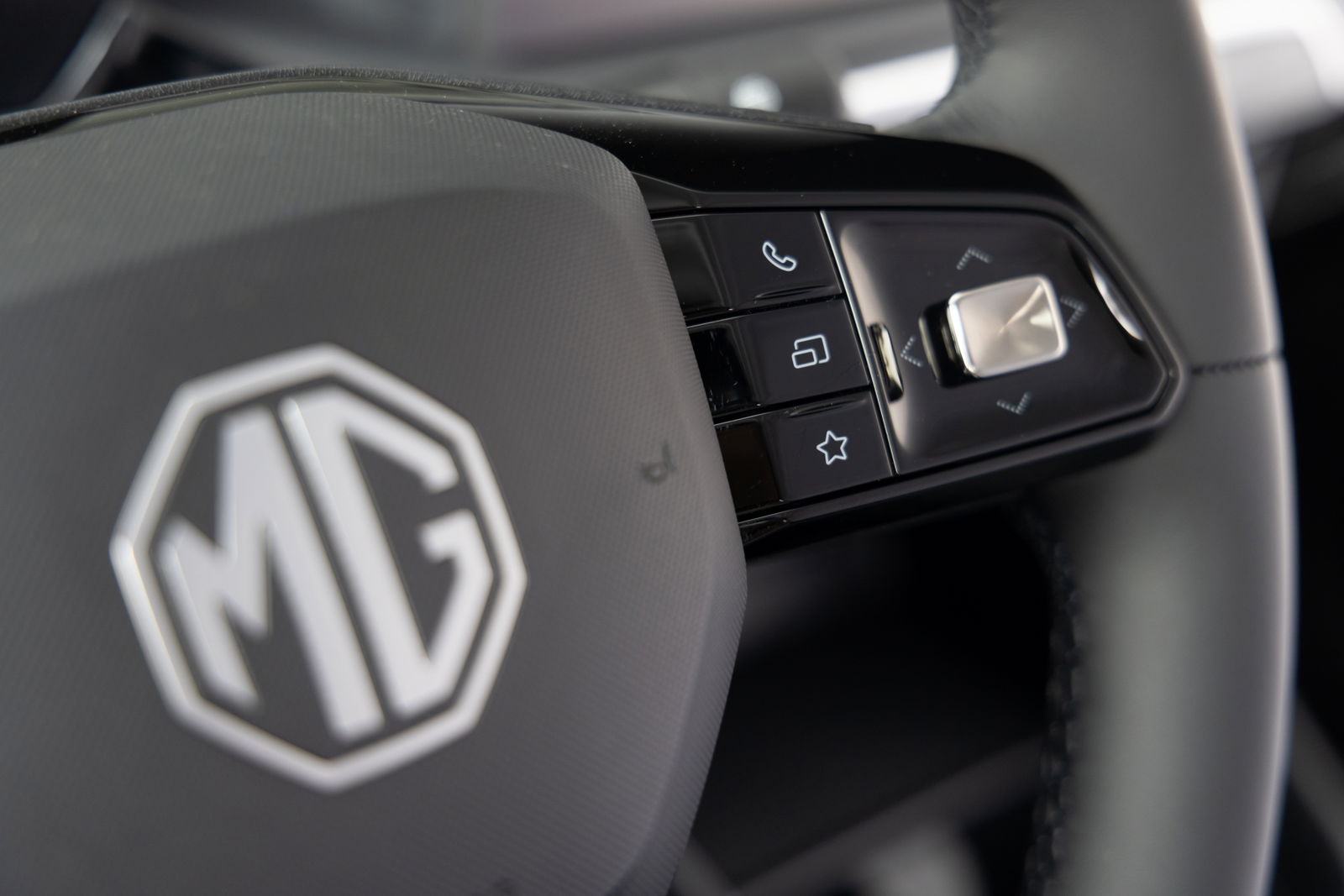Volante con controles multimedia y emblema MG en relieve.