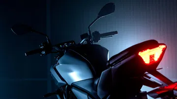 Lateral de la Yamaha MT-07 2025, iluminación agresiva y líneas modernas.