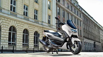 Vista lateral Yamaha NMAX 125 en ambiente urbano, destacando su diseño compacto.