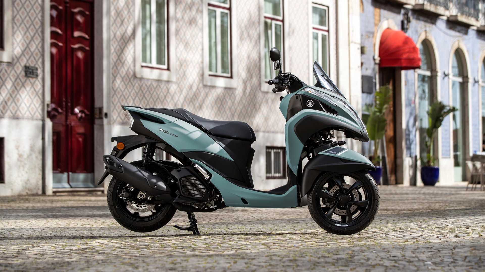 Vista lateral Yamaha Tricity 125, énfasis en su diseño de tres ruedas.