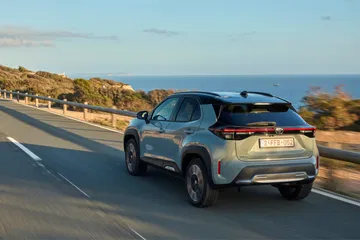 Toyota Yaris Cross Hybrid en carretera con paisaje costero