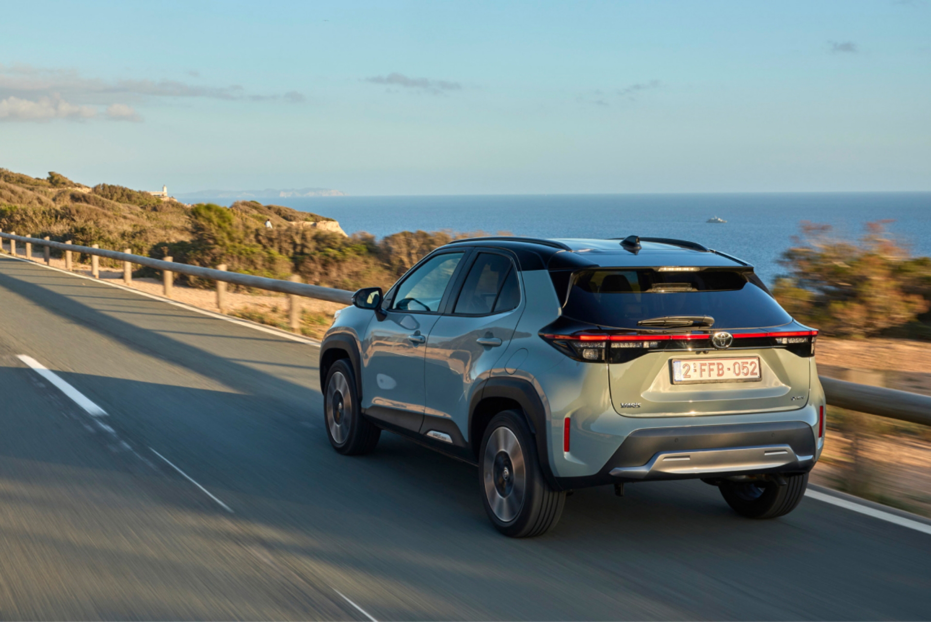 Toyota Yaris Cross Hybrid en carretera con paisaje costero