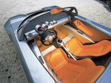 Vista del habitáculo deportivo con asientos de cuero en tonos naranja.